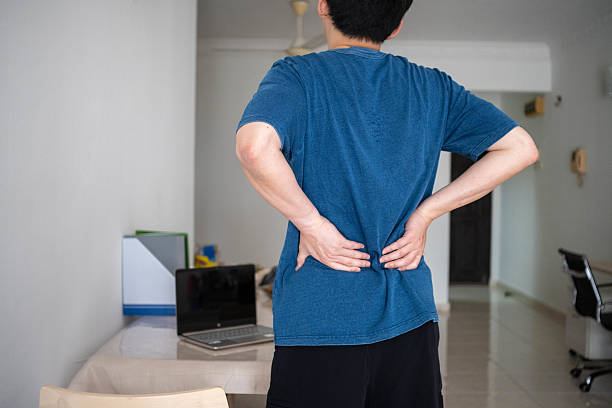 istock Back Pain Relief Needed: Male Touching Sore Lower Back at Home 2233016325
