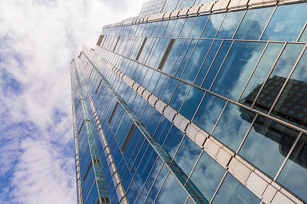 istock Modern skyscraper with reflective glass facade under a cloudy sky 2233019467