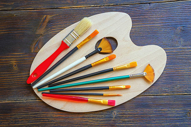 istock Palette and various types of artistic paintbrushes on dark rustic table. Flat lay 2233022376