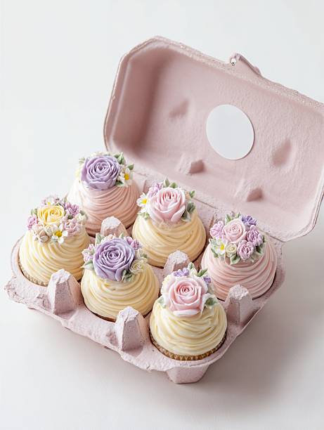 Delightful pink box of beautifully decorated cupcakes with floral icing