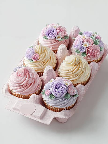 Delightful pink box of beautifully decorated cupcakes with floral icing