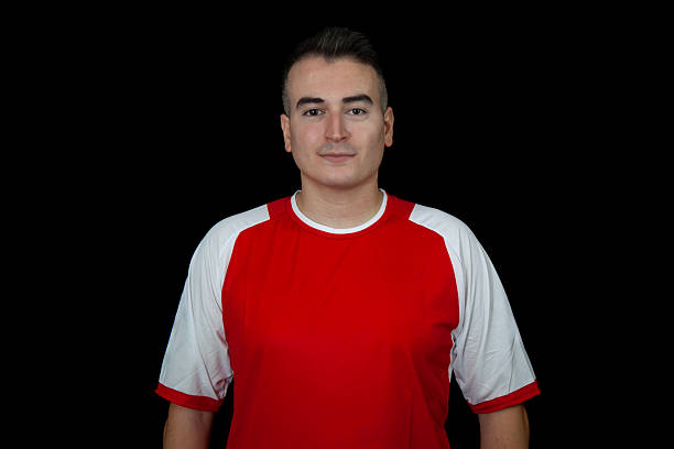 istock Footballer on red uniform on black background 2233030710