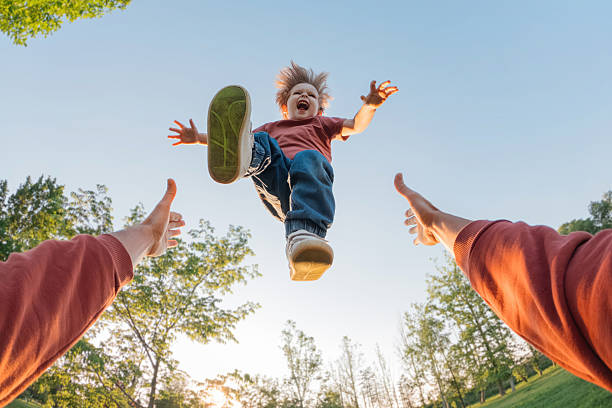 istock Laughing child midair above father's hands 2233032906