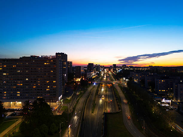 A vibrant city view captured at sunset showcasing illuminated streets and modern architecture. The image features urban life, transportation, and a colorful horizon. Perfect symbolism for business, daily life, and city living. Visualize serene twilight blending with dynamic city energy.
