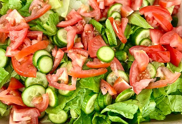 istock Salad preparation- Fresh chopped cucumber, tomato, and lettuce strips 2233035162
