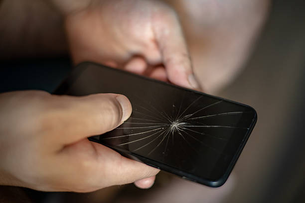 Close-up view of a modern smartphone with a severely cracked screen