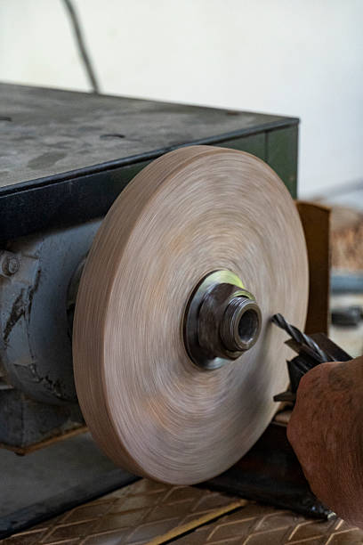 istock Worker grinding a metal tool on a spinning wheel 2233040248