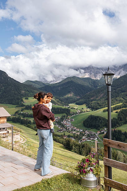 Mother and child admiring the stunning view of the italian dolomites, surrounded by breathtaking mountains and serene landscapes