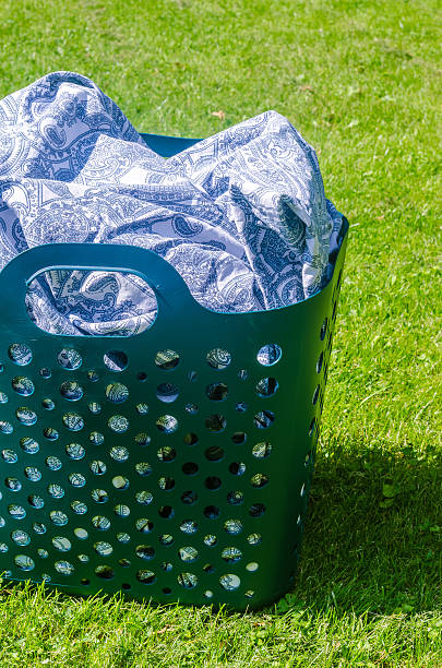 Laundry basket with patterned fabric on fresh green grass in sunlight