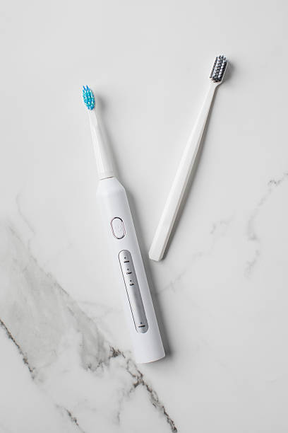 Manual and electric ultrasonic toothbrushes on a light background. Choosing a toothbrush.