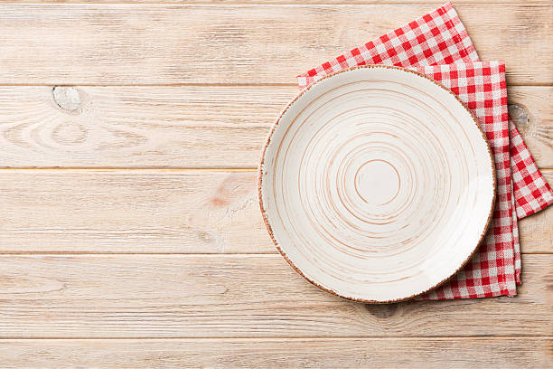 istock Top view on colored background empty round white plate on tablecloth for food. Empty dish on napkin with space for your design 2233056299