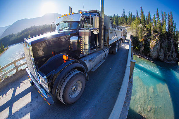 A Semi Truck Drives on Highway in the Canadian Rockies, Alberta, Canada.