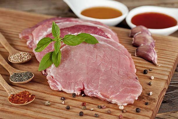 Pork chop condiments and bowls of sauce on a cutting board horizontal shot