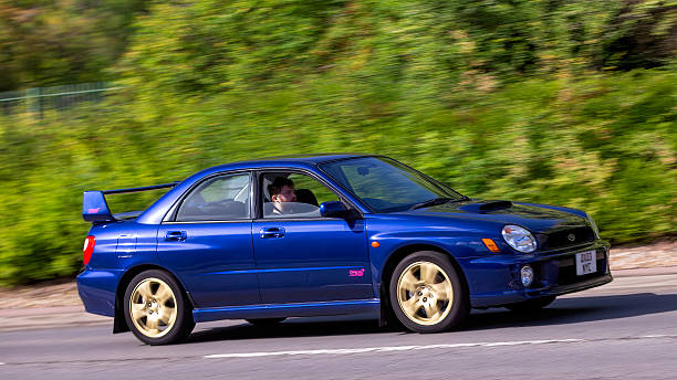 View from a very fast car in motion - urban city scene with abtract motion blur and focus on the side view mirror.