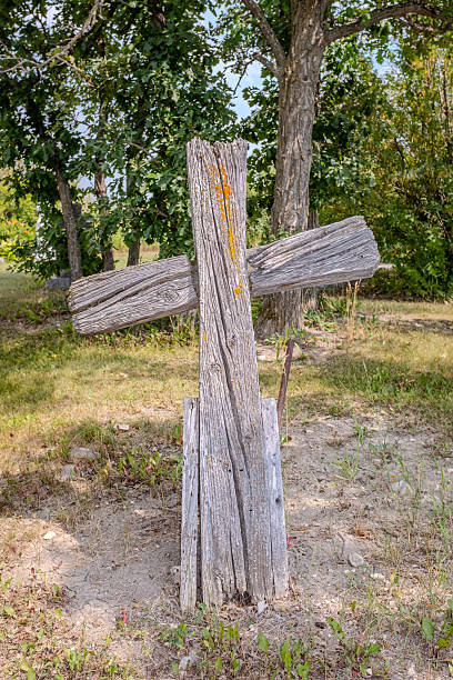 An unmarked grave, remembered only by a weathered wooden cross, standing quietly against time.