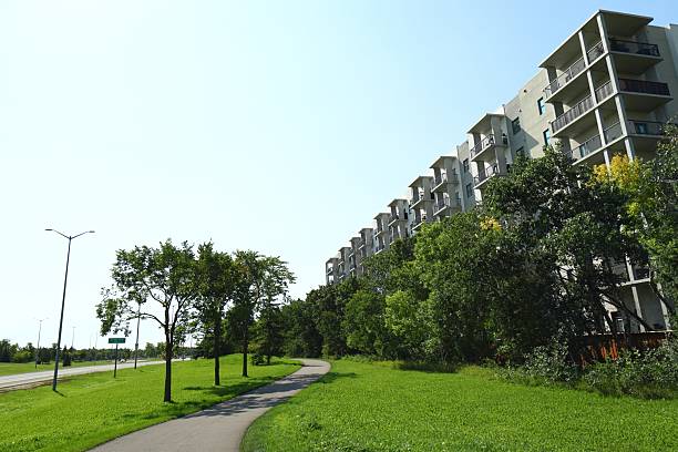 istock Modern apartment building with green trees and walkway 2233067227
