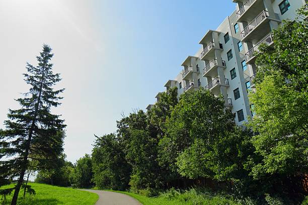 istock Modern apartment building with green trees and walkway 2233067248