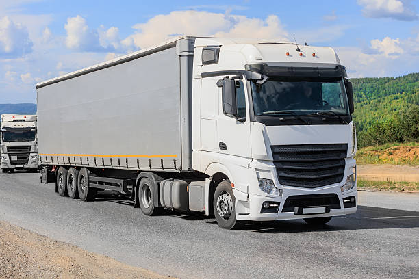 istock Big trucks driving on country road 2233067296