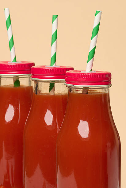 istock Glass bottles with tomato juice with red caps. 2233067956