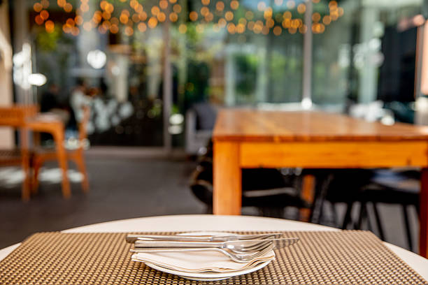 Newcastle, UK - Apr 13, 2025 - Looking through the glass into the Dining table and chairs inside an older vintage restaurant with sunlight shining through in Newcastle upon Tyne, use it as your Wallpaper, Poster and Copy space, Selective focus.