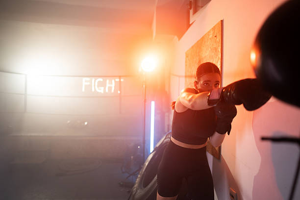 istock Focused Woman Training in Boxing Gym with Intense Lighting During Workout 2233070958