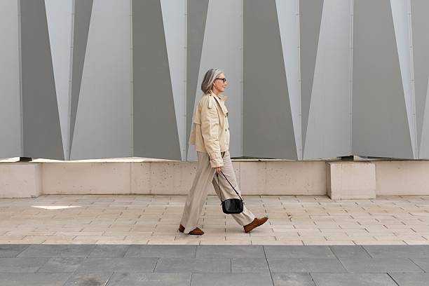 istock Senior woman walks confidently along modern architecture in urban setting under bright daylight 2233073632