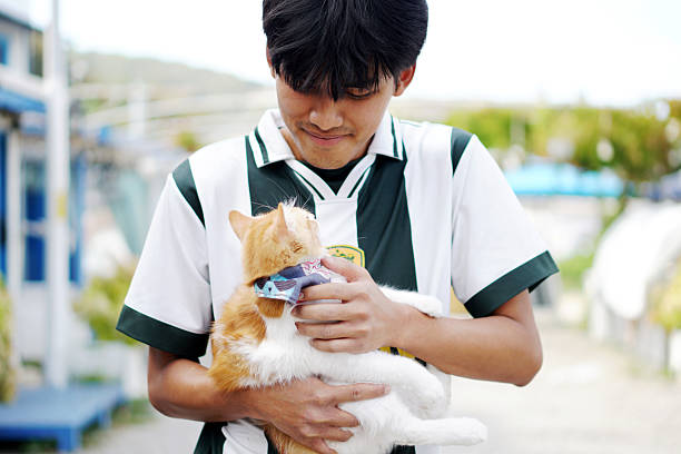 Young Indonesian man with a cat on his lap