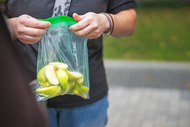 istock Female hands holding a plastic zip bag with sliced apples and pears for a snack 2233080652