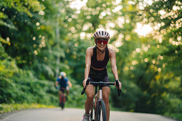 istock Smiling female cyclist leading the pack on a forest road 2233083233