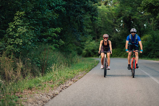 istock Smiling cyclists riding bicycles on scenic forest road 2233083301