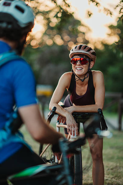 istock Smiling cyclist leaning on bicycle talking to friend 2233083336