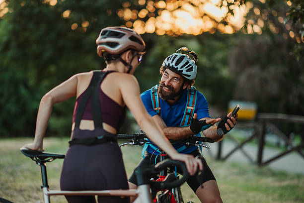 istock Cyclists discussing route on smartphone during sunset break 2233083340