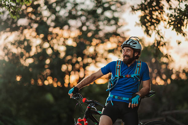 istock Smiling cyclist resting on his mountain bike at sunset 2233083364