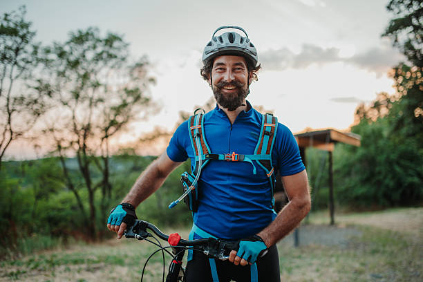 istock Mountain biker smiling and holding his bicycle at sunset 2233083372
