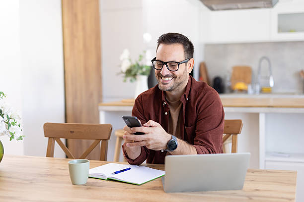 istock Cheerful Man Smiling at Smartphone in Bright Atmosphere 2233087412
