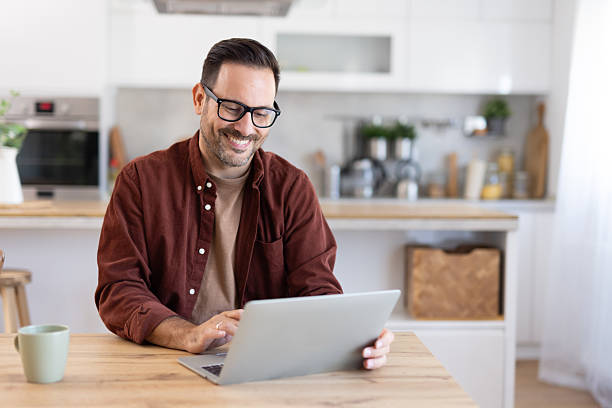 istock Happy Man Smiling While Working on a Laptop at Home 2233087422