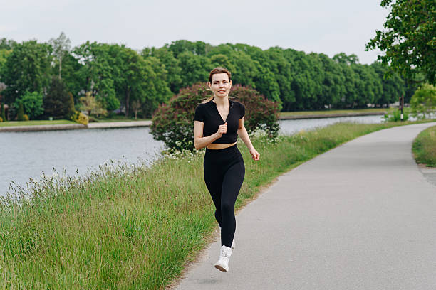 istock young woman runs in city park 2233087640