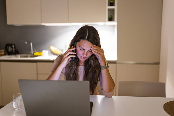 istock Stressed Woman Working Late on Laptop in Kitchen 2233089639