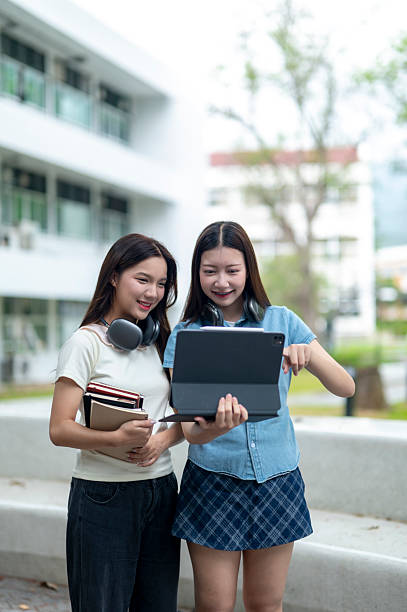 istock Two young female students sharing a digital tablet during break time at university campus 2233091274