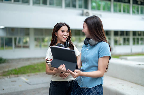 istock Two young female students talking and smiling outdoors at university campus 2233091276