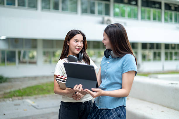 istock Two young female students sharing a digital tablet outside university building 2233091278