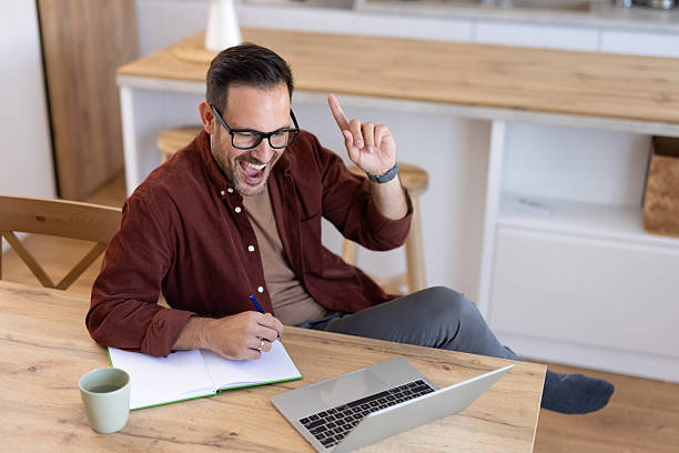 istock Excited man celebrating success at home workspace 2233092345