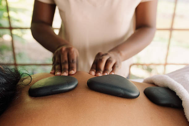 Close-up of hot stones on woman’s back