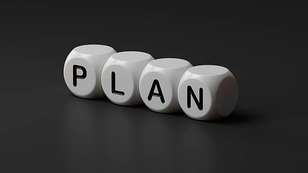 istock plan. wooden dice spelling.Flat lay view from above on wooden dice buttons.IT technology concept.3D rendering on black background. 2233095539