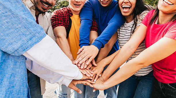 istock Group of multiracial friends stacking hands in outdoor park, unity and teamwork concept 2233097117
