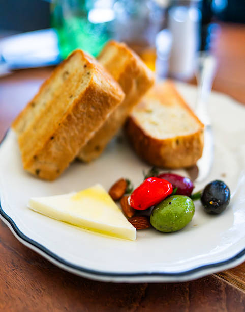 Plate of bread slices with cheese, olives, and almonds