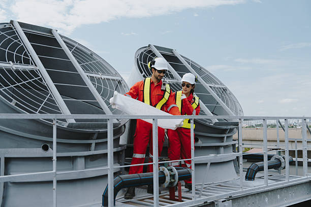 istock Industrial engineers working as a team, maintaining pipes, valves, air conditioning, refrigeration, HVAC systems at construction site. Male technicians in red safety uniforms checking pipe valves. 2233107475