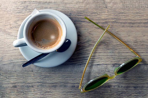 Cup of Coffee Adjacent to Sunglasses on Wooden Surface