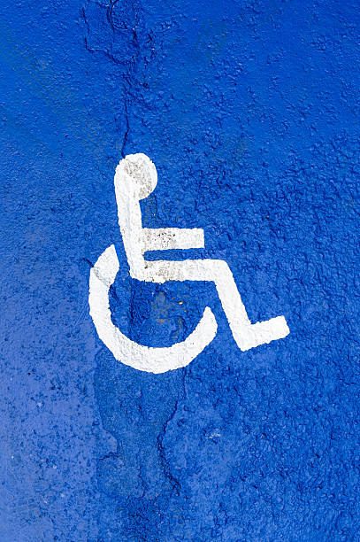istock Symbol for a disabled parking space on an asphalt road 2233110493