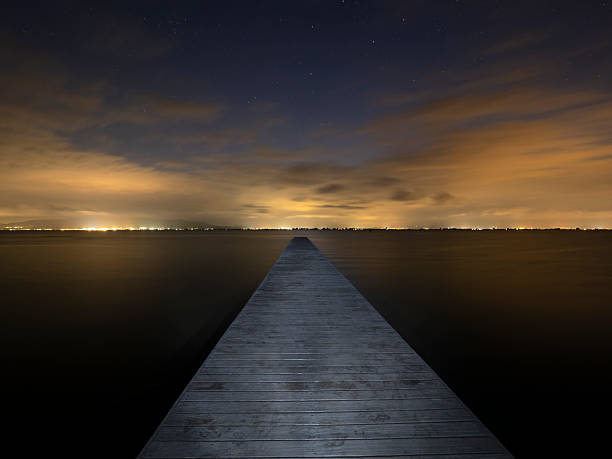 istock Illuminated pier over the sea at night 2233110593